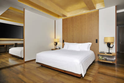 スタンダードな客室「オーシャンルーム」の寝室。ウッド調を基調にしたシンプルで心地よい空間。健康目標達成をサポートするディスティネーション・スパであることから基本的に最低3泊からになる