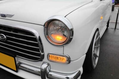 ダイハツ ミラジーノ：純正ライトを取り外し、2輪用ヘッドライトに交換している