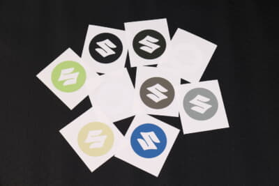 スズキ ジムニーノマド:純正ホイールキャップ用ステッカーは、ジャングルグリーン、シフォンアイボリーメタリック、ピュアホワイトパール、ブルーイッシュブラックパール、ミディアムグレー、キネティックイエロー、スペリアホワイト、ブリスクブルーメタリック、シルキーシルバーメタリックの9色を用意