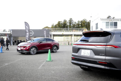 コースインするクラウンエステートとピットインする日産リーフ