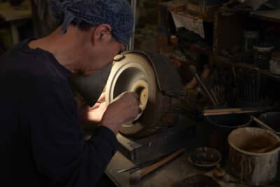 使用済みのクルマの窓ガラスを分別・破砕したあと、タンブラーやロックグラス、花瓶などを作製している