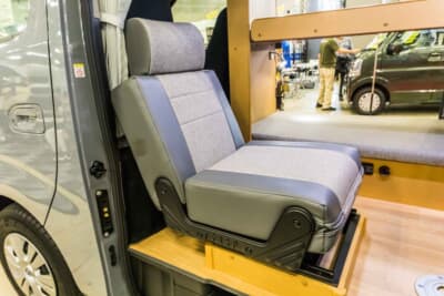 日産 キャラバン:前側のシートは背もたれを反転して進行方向向きのシートにアレンジ可能であり、走行中のシートとしても機能する仕組みである