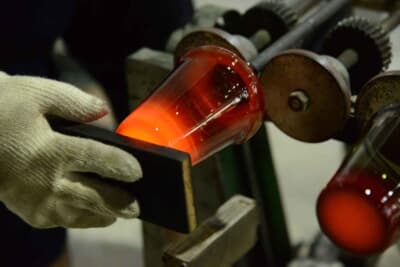 使用済みのクルマの窓ガラスを分別・破砕したあと、タンブラーやロックグラス、花瓶などを作製している