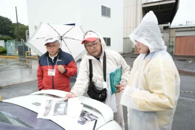 ホンダ ビート：まずはシザーズドアに興味を持ち、車中泊仕様に気づいて驚く見学者たちに、その設計図や使用写真を説明する濱砂さん