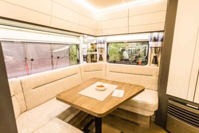 495UL エクセレント エディション：車体右側面の後方に設置されたドアから車内に入ってみると、コの字型に配されたソファと木製テーブルが目に飛び込んでくる