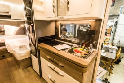 495UL エクセレント エディション：キッチンは、シンクも大きく、3口もある本格的なガスコンロだ。その脇の冷蔵庫も縦型で、133Lもの容量を誇る。独り暮らしのアパートよりもよっぽど豪華な内容といえる