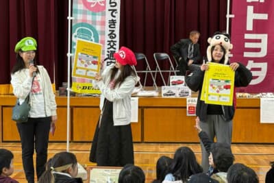 京都市立下鳥羽小学校で、カーライフジャーナリストのまるも亜希子さんと一緒に「OKISHU」の交通安全応援活動を行いました