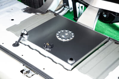 AMEND：リヤゲートを開けたすぐ真下。通常ならスペアタイヤを積んでいるあたりに薄型の燃料タンクを移設。極限まで薄さを求めるためにはこんな加工も絶対に必要です