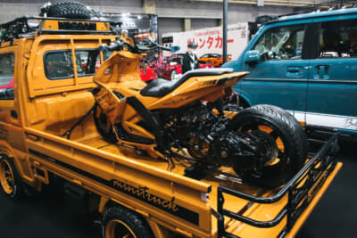 クルマと同色のカスタムされたスクーターが積載されている遊び心満載の展示