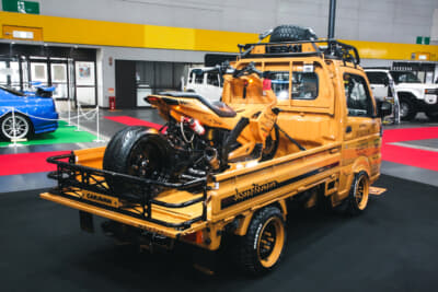 クルマと同色のカスタムされたスクーターが積載されている遊び心満載の展示