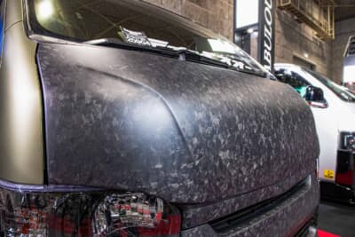 トヨタ ハイエース：ボンネットに施されたフォージドカーボン加工のクローズアップ。大理石を思わせるマーブル模様が、平織りや綾織りとは一線を画す独特の表情を生み出している