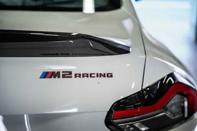 BMW M2 CS Racing ： トランクに輝く専用エンブレム。BMW Mモータースポーツが手掛けた本物のカスタマーレーシングカーである証であり、世界中のサーキットで戦うチームの誇りでもある