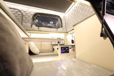 三菱 トライトン：ダイニングのテーブルはベッドへの展開が可能で、大人でもゆったりとくつろげる就寝スペースを作り出せる