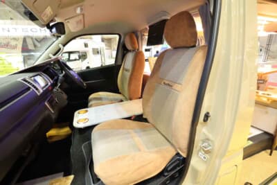 トヨタ ハイエース：フロントシートにも内装のテイストに合わせたシートカバーが装着されており、車内全体で統一感のある仕上がりとなっている