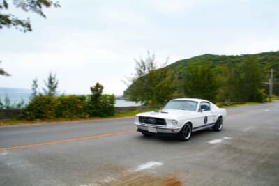 国道58号線のシーサイドコースを快走する1967年式フォード マスタング ファストバック。2日目は時おり雨に見舞われたが、天候をものともせず心地よいV8サウンドを轟かせていた