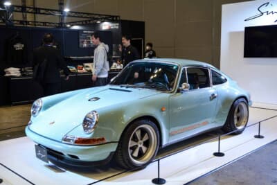ポルシェ 911 リイマジンドbyシンガー・クラシックスタディ：コーンズのブースに展示されたペールブルーの個体。964系 911のスチールパネルを多く残したボディに、ナロー時代のスパルタンな空気をまとう
