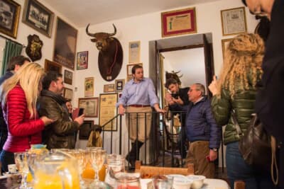 スペインのパティオのような場所で、熱心に説明に聞き入るツアー参加者たち。誰もがミウラSVのステアリングを握ることを希望していた