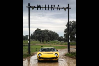 伝説の「MIURA」ゲート。山崎さんが自らの手でドライブしてきたP400ミウラSV（S/N 5092）が、木製のゲートを通り抜けて聖地へと到着した瞬間だ