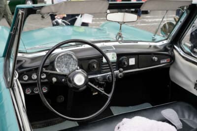 大径のスピードメーターがステアリング中央に備わるAMC メトロポリタンのシンプルなデザイン。ダッシュボード左下の3連メーターは追加されたものだ。中央のステッカーは、オーナーの若尾さんが代表を務めるホンダ スーパーカブに特化したカスタムショップのもの