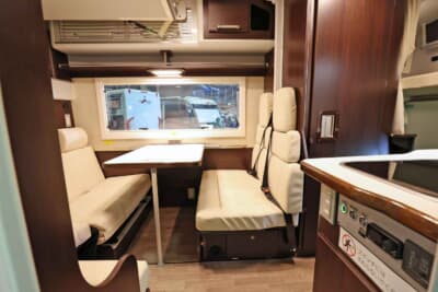 レガードNeo+:車内へと足を踏み入れると、上質なレザーシートと落ち着いた木目調家具が広がるダイネット(リビング)空間が現れる