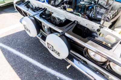 日産 バイオレット・オースター 1400DX：CIBIEフォグランプの取り付け状態。悪路での振動対策として、トップ側もコアサポートとステーで固定されている