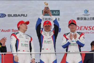 表彰台でトロフィーを掲げるジンズー・スン（中央）、アダリー・フォン（左）、太田格之進（右）。SUZUKA 5時間レースの総合優勝チームが喜びを分かち合った