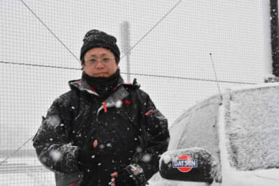 日産 ブルーバード SSS-R：雪降るなか、愛車ブルーバードSSS-Rの隣で笑顔を見せるオーナーの湯川峰さん