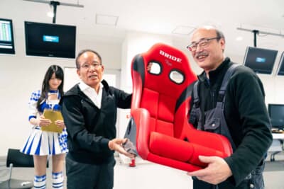 ブリッドの高瀬社長（写真左）がフルバケットシート「ZETA IV」を直接プレゼント。これには当選した参加者もニッコリ