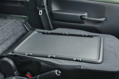 スズキ スーパーキャリイ Xリミテッド：助手席の背もたれを前倒しにしたテーブル状態。シュンをシートバックスペースへ乗せる際にもこの機構を活用した