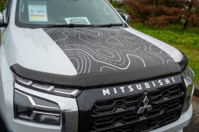 三菱 トライトン：オリジナルのトポグラフィ柄をボンネットのセンター部分に配置している。フロントフェイスのアクセントとなるバグガードは、オーストラリア純正のアイテムを採り入れたこだわりの仕様だ