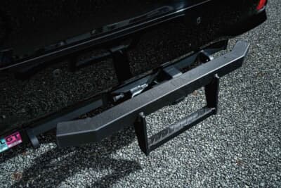 トヨタ ヴェルファイア：エアロパーツは装着せず、リフトアップした車高に社外品のヒッチメンバーを組み合わせた。オーナーが自作したヒッチステップを追加して実用性を高めている