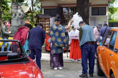 葛西神社の香山伸一宮司による交通安全のお祓いを受ける、展示車両とそのオーナーたち