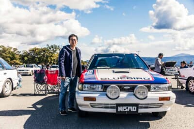 日産 ブルーバード SSS-R:赤・白・青のトリコロールを基調としたステッカーグラフィックは、U12クラブのメンバーの協力を得て再現されたもの。オーナーの新谷さんが愛車の傍らに立つ