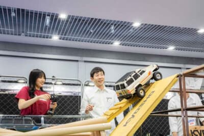スタッフのアドバイスを受けながら岩山コースでラジコンを走らせる