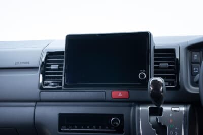 トヨタ ハイエース：全車に標準装備された8インチのディスプレイオーディオ。スマートフォン連携に対応しており、ナビゲーションや車両情報の統合によって実用性が大きく向上した。インテリアの進化の要だ