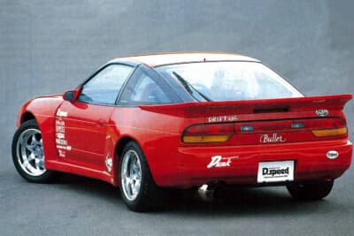 日産 180SX:真っ赤なワイドボディに直付けリアスポイラーを組み合わせ、サイドにはDスピードやアペックスのステッカーを配する