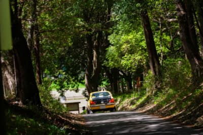 三菱 ランサー1600GSR:木漏れ日が差し込む林道を駆け抜けるスポーティな後ろ姿