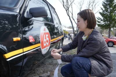 ルノー サンク:通算35回目の記念大会に出場するためゼッケンを貼り付ける奈央さん