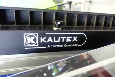熱可塑性複合材で成形されたバッテリーケースのエッジ部分。Kautexのロゴとともに「A Textron Company」の文字が刻まれている