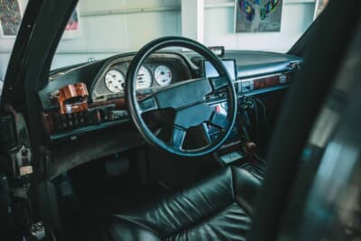 メルセデス・ベンツ560SEL AMG 6.0-4V AMGステアリングホイールとホワイトフェイスのメーターが存在感を放つコクピット。AMG専用ウッドパネルが高級感を添える