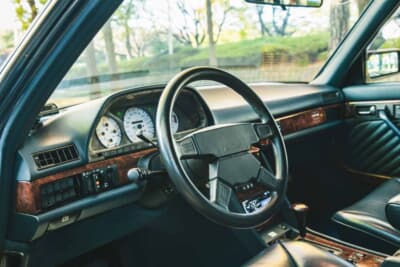 メルセデス・ベンツ 560SEL AMG 6.0-4V:AMG製ステアリングと白基調の専用メーター、そしてウッドトリムが運転席まわりを特別な空間にしている