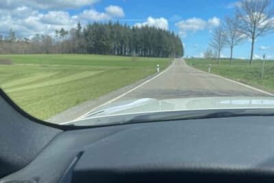 車窓から見える美しい青空と綺麗な道路。ルールと社会全体の合意がこの景色を作るのだ