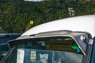 スバル サンバーバン: フロントガラス上部に取り付けられたバイザー。ワイパーも自身で缶スプレーを用いて塗装するなどDIYを満喫している