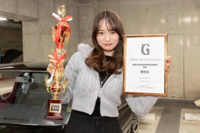 トヨタ クラウン:ガールズカーコレクションで受賞したトロフィーと盾を掲げるやまださん