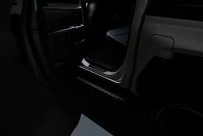 トヨタ 新型ハイラックス: LEDスマートフットライトの点灯イメージ。写真は、後席の左側。足元が柔らかく照らされて夜間の乗り降りをさり気なくサポート