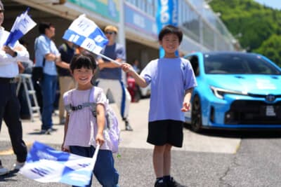 PROXES DRIVING PLEASURE:今年はPROXES誕生35周年なので記念フラッグを製作。参加者へ熱い声援を送る姿が印象に残った