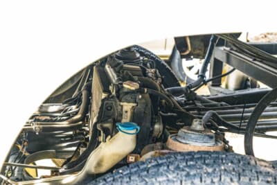 スバル サンバー トラック：ボディをフレームから大きく持ち上げたことで露出したラジエーターなどキャビン下の機器類