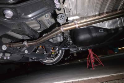 トヨタ ヴェルファイア：中間部分をメンバーの上から通すことで腹下のクリアランスを確保したマフラーの中間パイプ