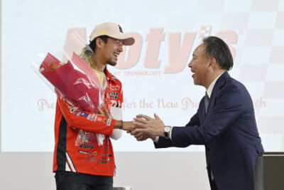 Moty’s：ダカール・ラリー2026で完走を果たした藤原慎也選手に花束を手渡す丸山会長