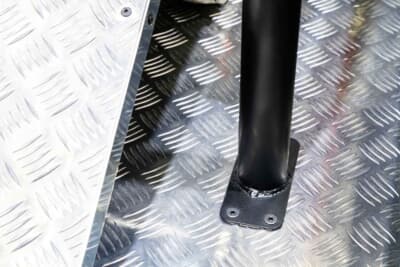 ダイハツ ハイゼット トラック ジャンボ スタークライマー：キャビンを保護する極太のスチールケージは、荷台のフレームに強固にダイレクトマウントされている。単なる視覚的なタフさだけでなく、100mmリフトアップされた車体が生み出す激しい挙動や、万一の転倒時にもキャビンを確実に守り抜く「実戦派」の剛性を確保